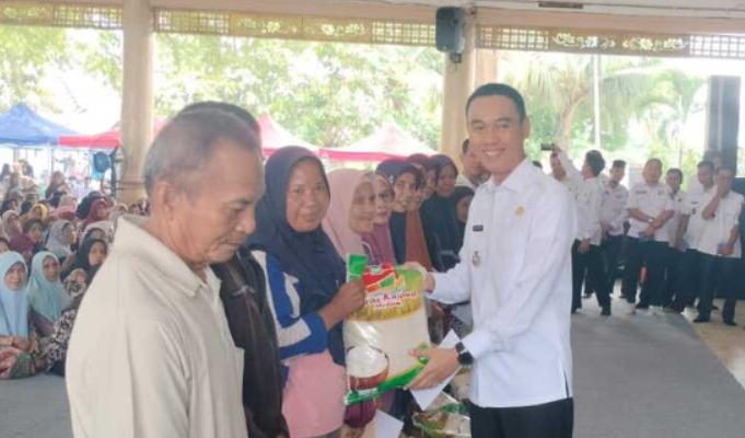 Bupati OKI Muchendi Mahzareki saat menyalurkan 1.129 paket beras kepada warga