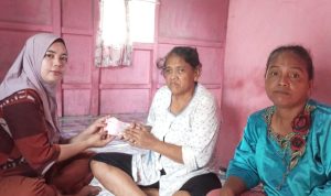 Ketua RT 006 Desa Marga Sungsang kecamatan Banyuasin II, Ira Rahayu saat menyerahkan biaya pengembalian berobat kepada Yani